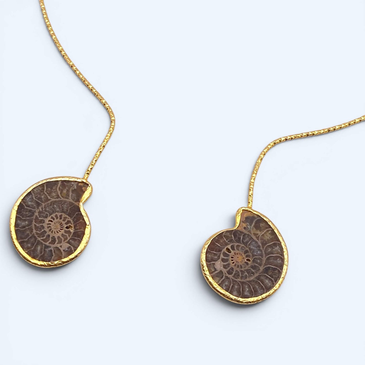 Vista em detalhe do Colar dourado aberto com amonites. De inspiração orgânica com fósseis e acabamento texturizado, é a gargantilha perfeita para cerimónias, festivais, festas de verão e looks mais glamorosos.