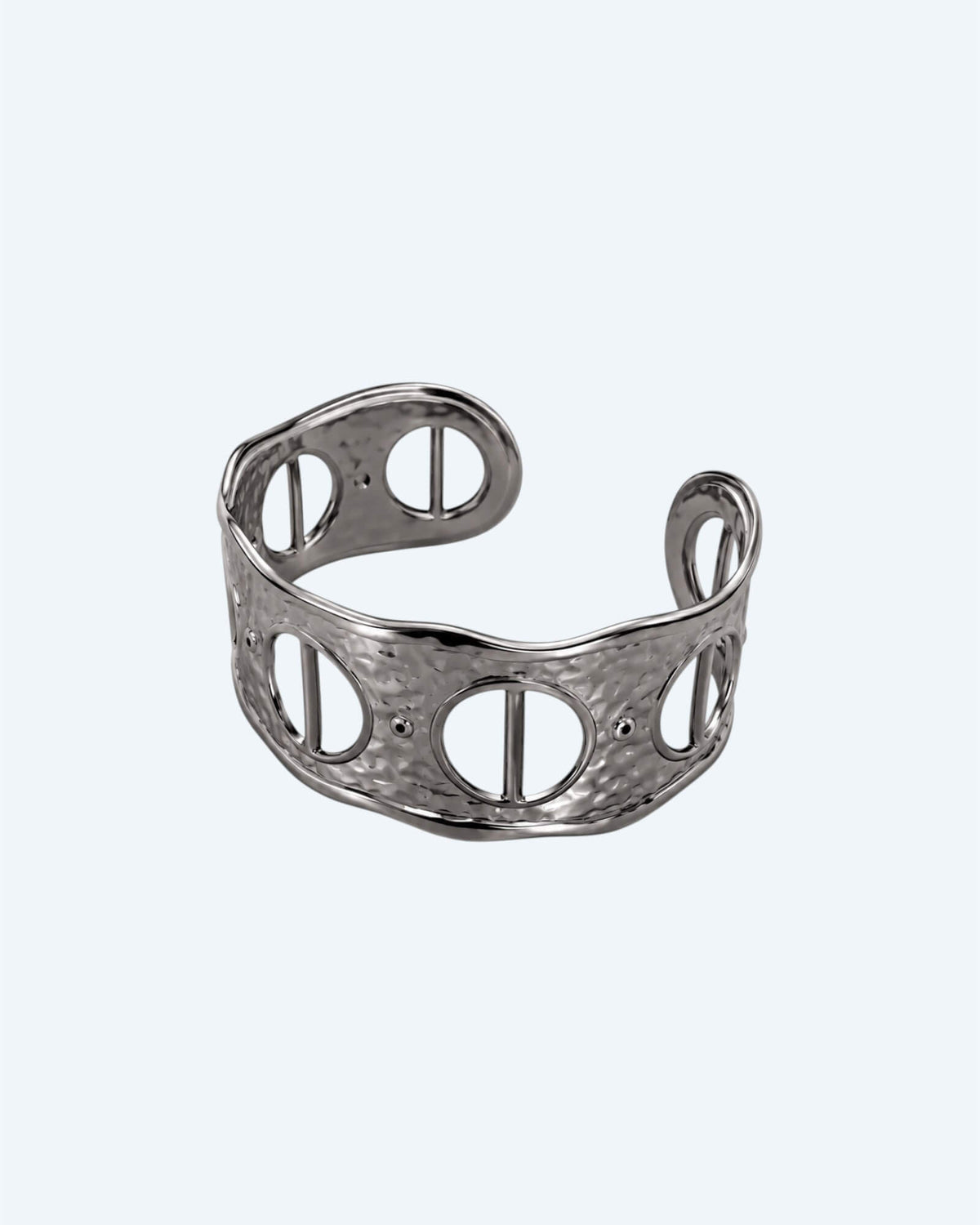Vista de frente da Pulseira prateada rígida, ajustável, em aço inoxidável, martelada com aberturas. Esta pulseira é uma versão contemporânea de boho vintage. É para quem gosta de looks marcantes ou para quem procura uma pulseira para usar numa ocasião especial ou cerimónia.