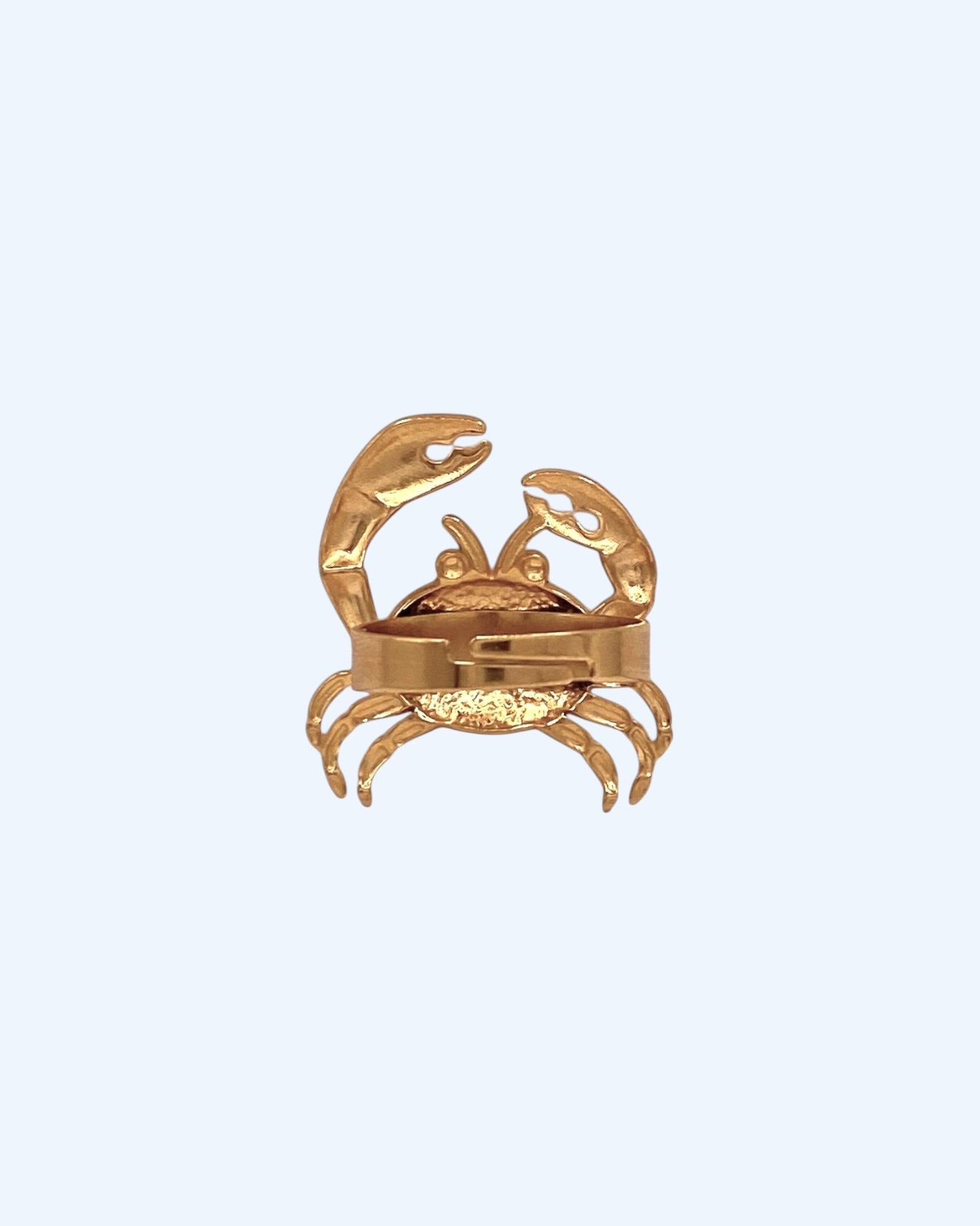Vista de trás do Anel dourado ajustável em aço inoxidável com forma de caranguejo. Um anel resistente à água, para ser usado em looks de verão, looks casuais e de festa. Um anel divertido de inspiração no mar e no verão.