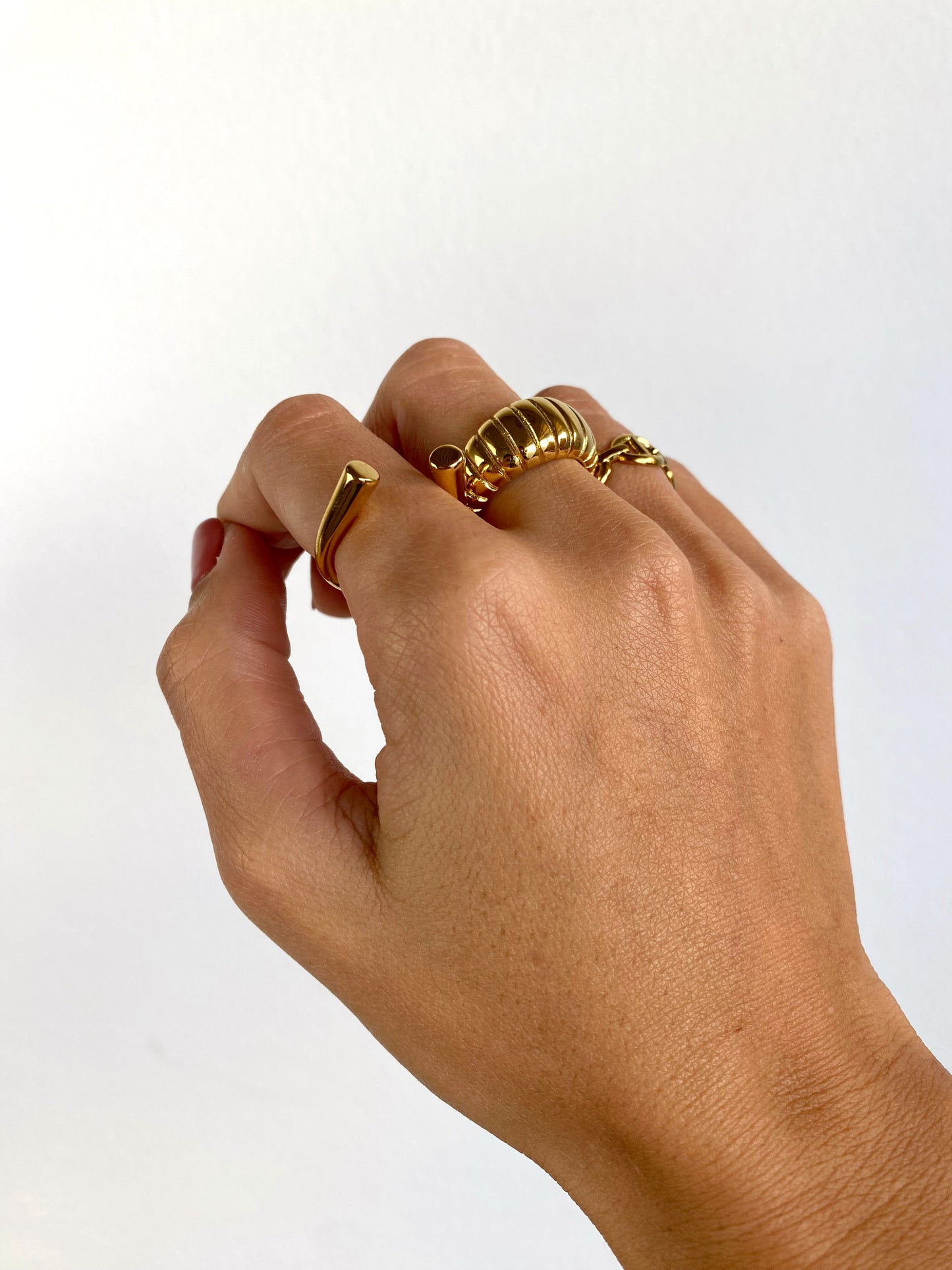 Vista a ser usado do anel grande, também chamado de anel chunky e anel bold, arredondado com vincos em aço inoxidável, versão dourado.