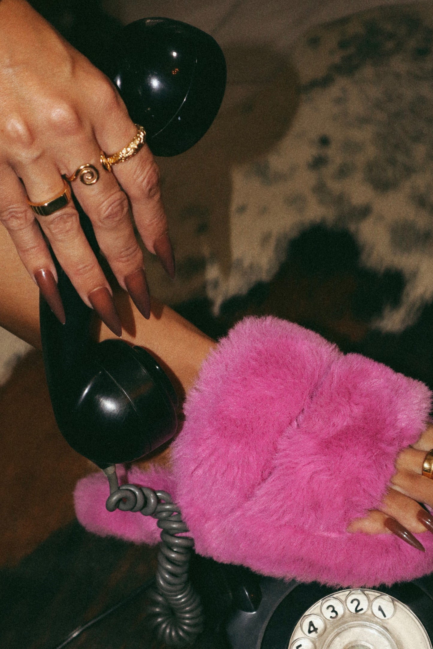 Vista do anel aberto com duas curvas, em aço inoxidável e ajustável dourado, a ser usado na mão com outros dois anéis.