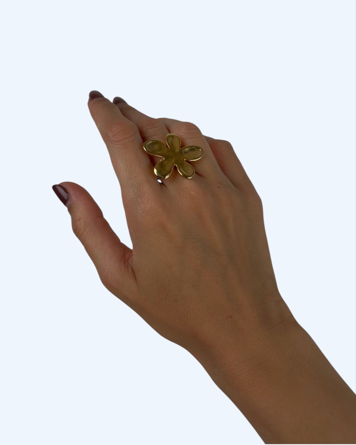 Vista a ser usado na mão do anel dourado com flor grande em aço inoxidável, Um anel bold e fun, perfeito para outfits de verão.