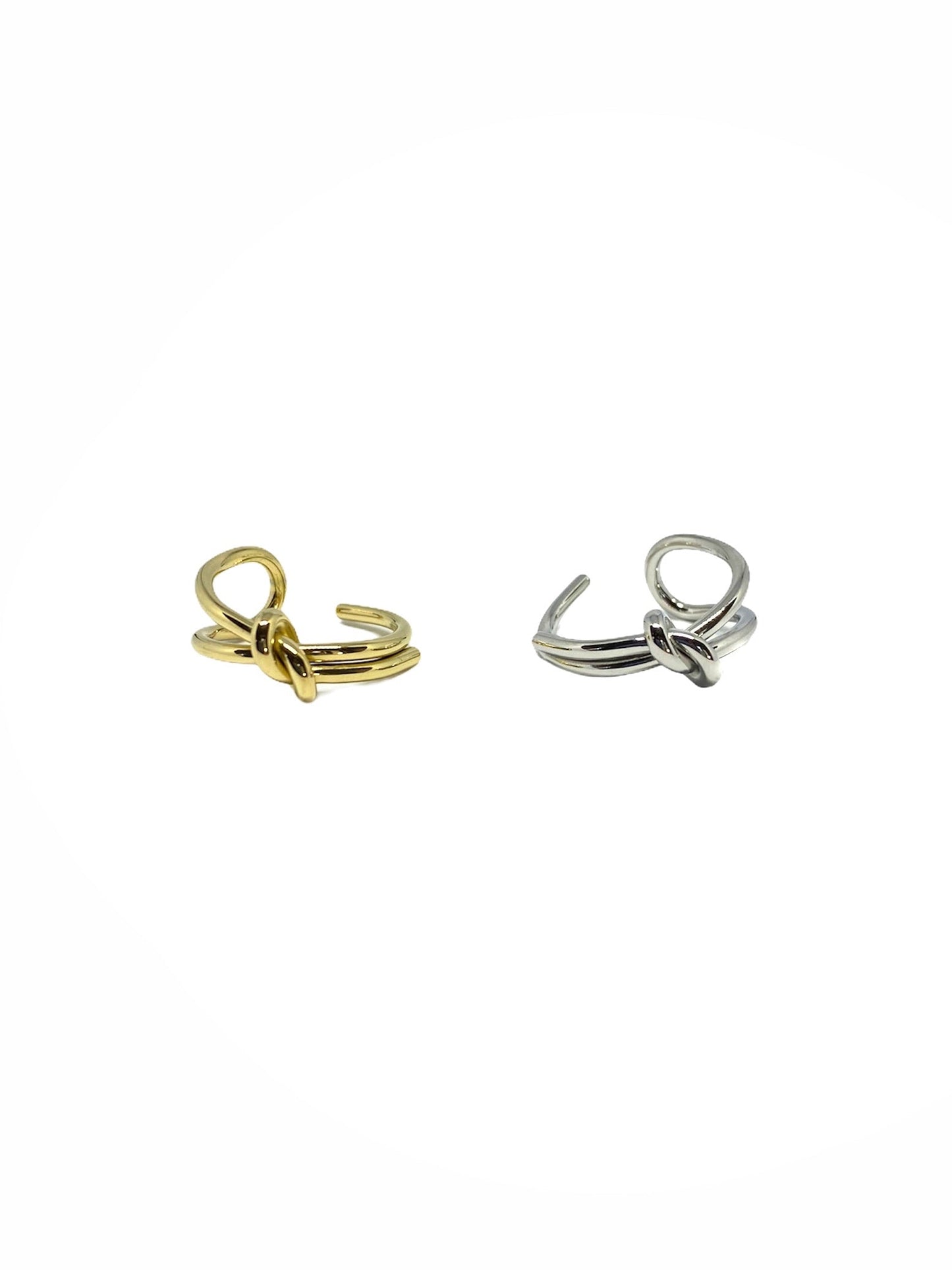 Vista frontal do Anel duplo com nó prateado em aço inoxidável e do Anel duplo com nó dourado em aço inoxidável.