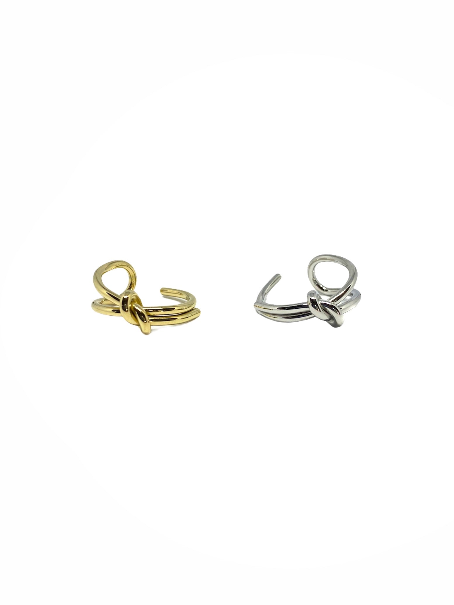 Vista frontal do Anel duplo com nó prateado em aço inoxidável e do Anel duplo com nó dourado em aço inoxidável.