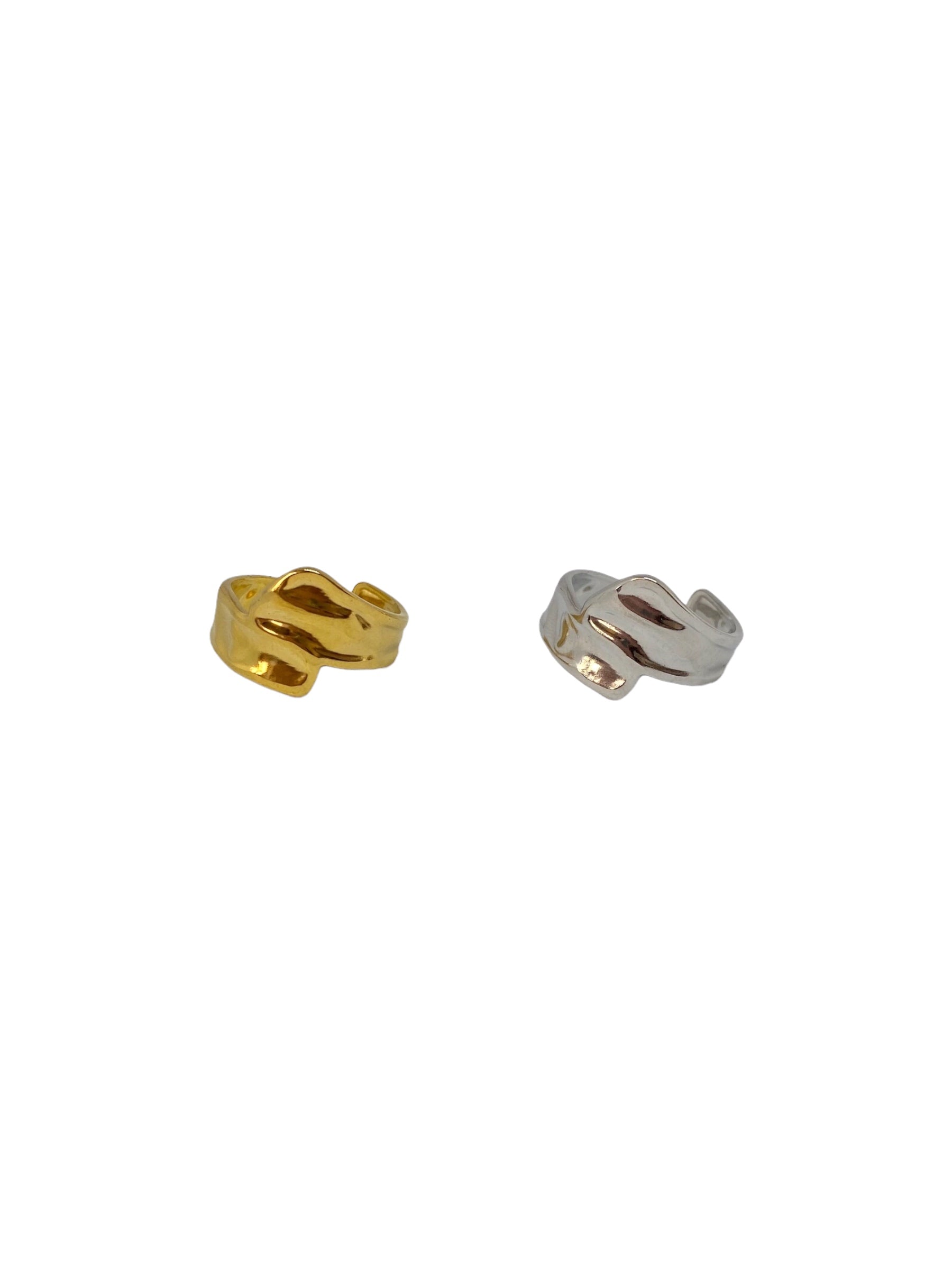 Vista frontal do anel dourado minimalista com duas tiras com textura orgânica que cruzam à frente e do anel prateado minimalista com duas tiras com textura orgânica que cruzam à frente.