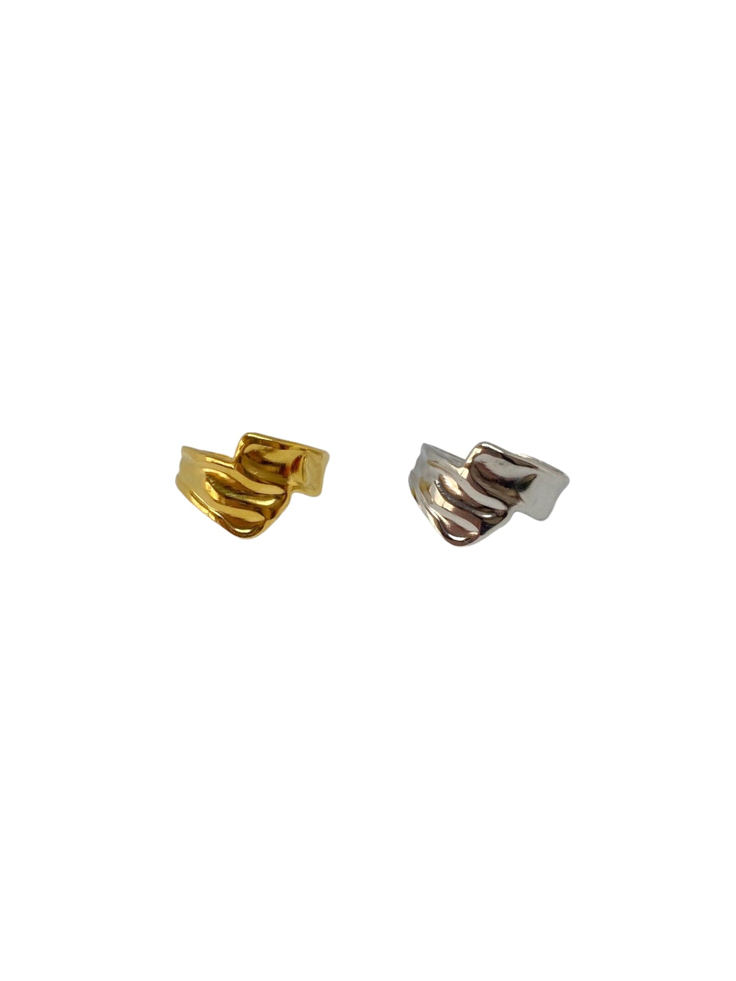 Vista frontal do anel dourado minimalista com duas tiras com textura orgânica que cruzam à frente e do anel prateado minimalista com duas tiras com textura orgânica que cruzam à frente.