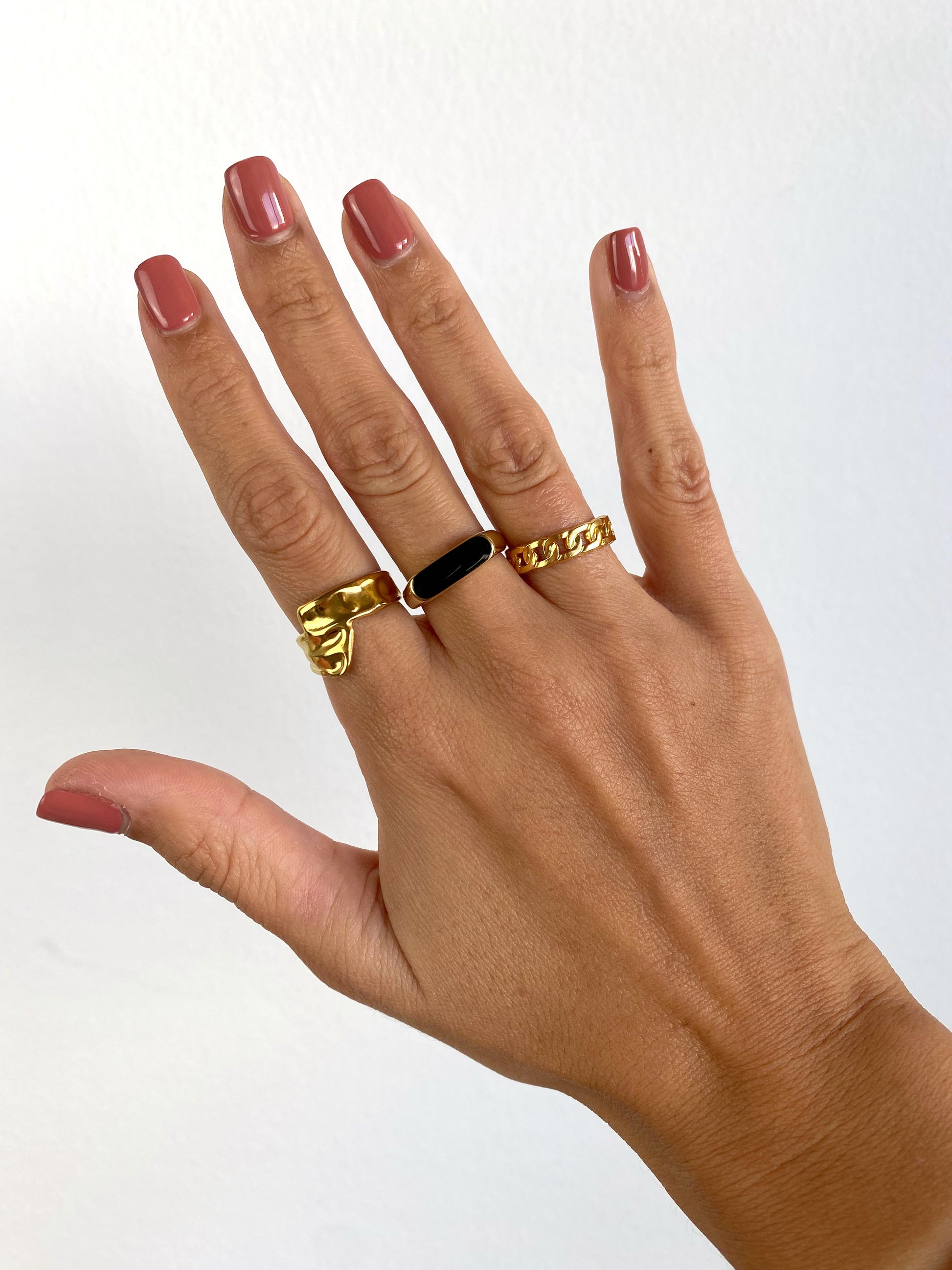 Vista a ser usado do anel dourado minimalista com duas tiras com textura orgânica que cruzam à frente.
