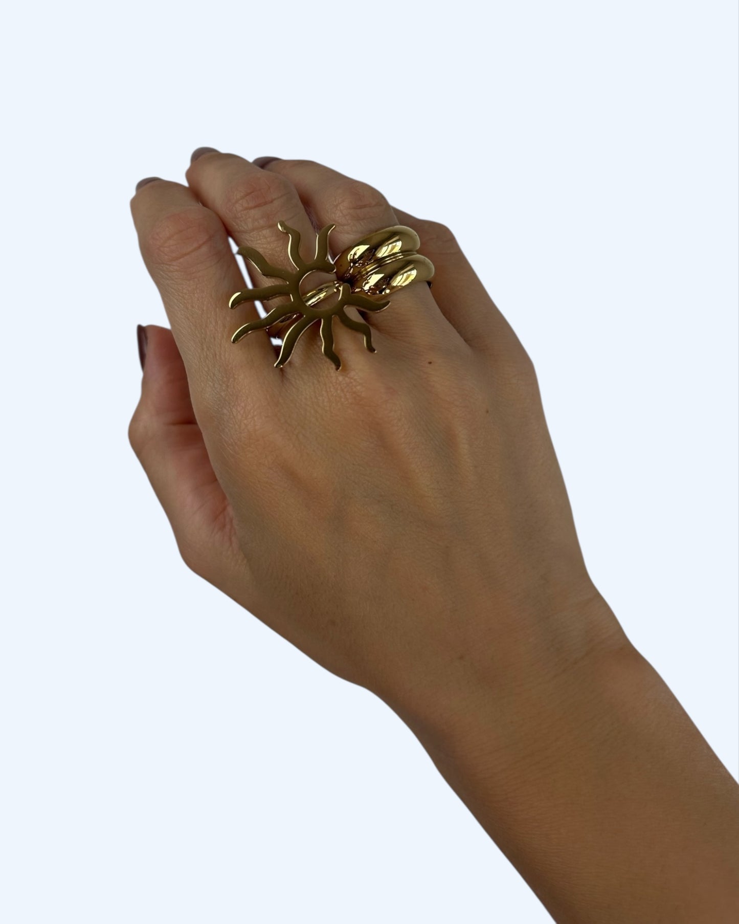 Vista de conjunto na mão do anel sol boho-radical dourado ajustável em aço inoxidável e do anel dourado largo, aliança dupla em aço inoxidável.