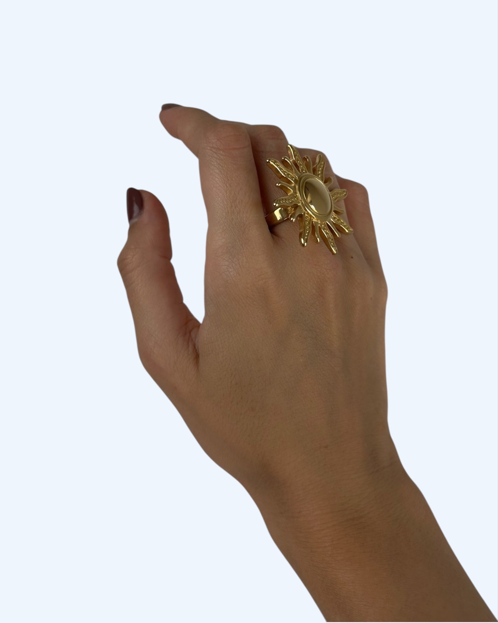 Vista do anel sol grande maxi dourado em aço inoxidável, a ser usado no dedo. Anel ideal para usar no dedo indicador.