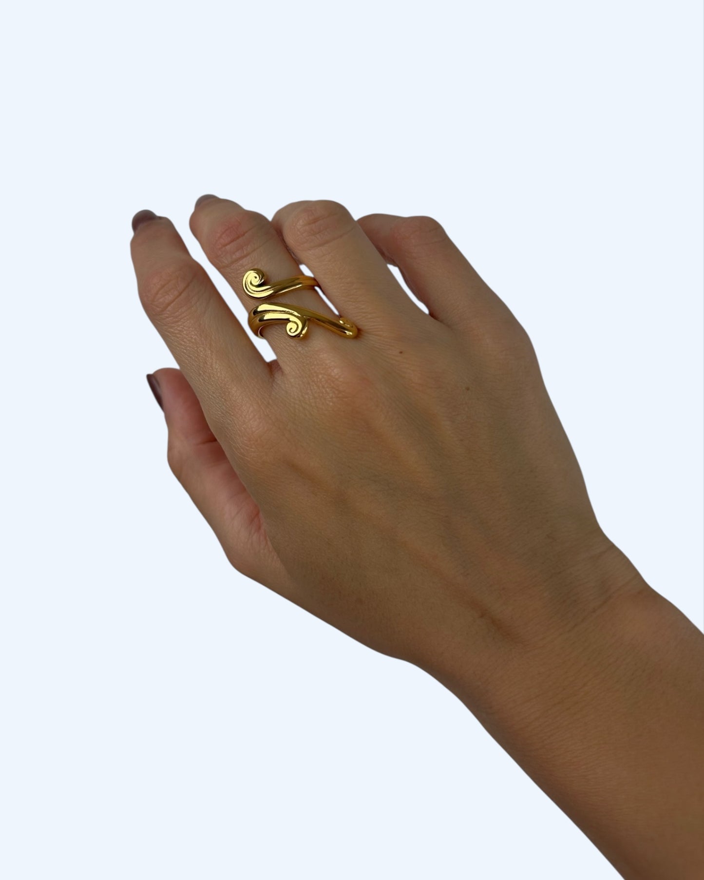 Vista a ser usado na mão do anel dourado em forma de trepadeira em aço inoxidável ajustável que contorna o dedo. Um anel romântico baseado na natureza.