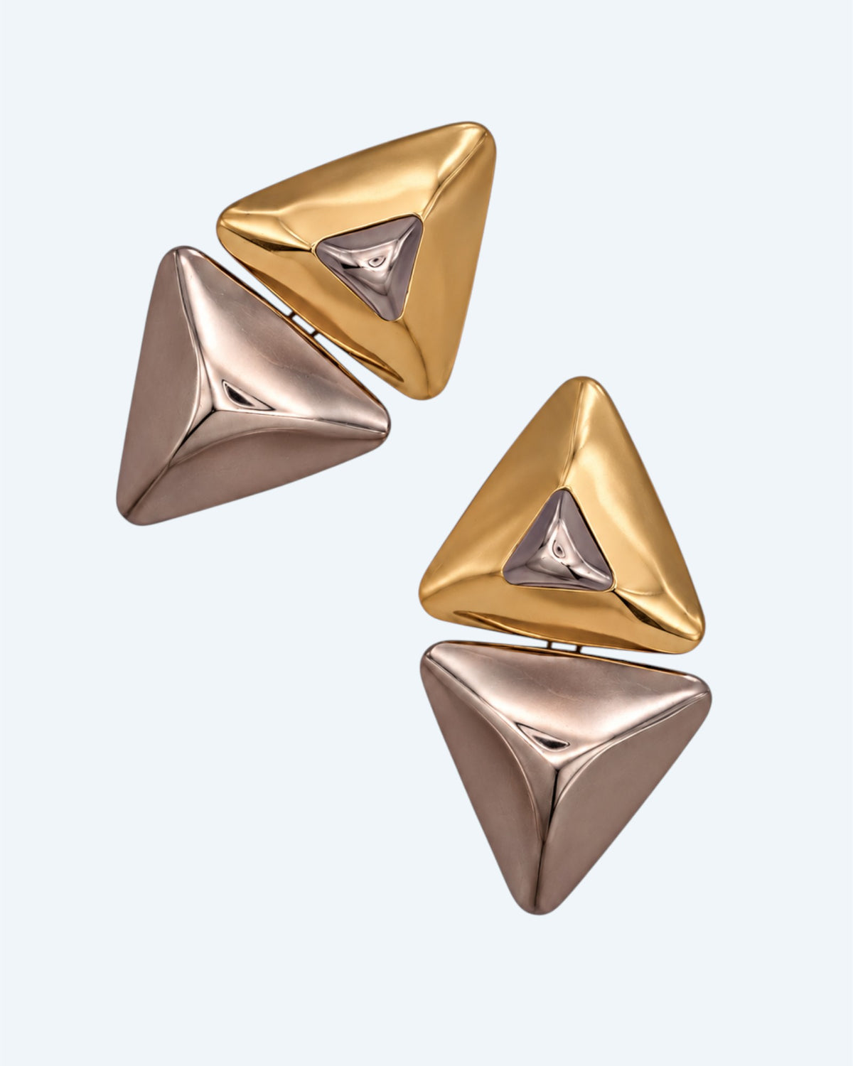 Vista lateral dos brincos geométricos triangulares em metal dourado e prateado. Brincos leves, contemporâneos, para o dia à dia e para festas.