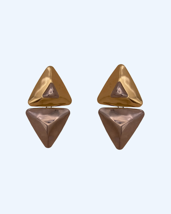Vista frontal dos brincos geométricos triangulares em metal dourado e prateado. Brincos leves, contemporâneos, para o dia à dia e para festas.