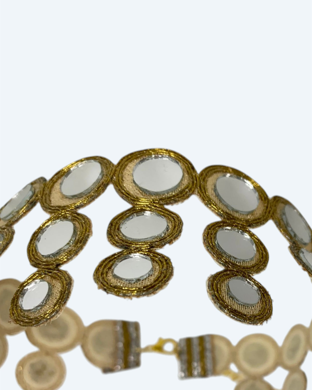 Vista do detalhe dos espelhos e do tecido, do choker dourado em faixa de tecido com espelhos redondos HALO. Colar ideal para festas e cerimónias. 