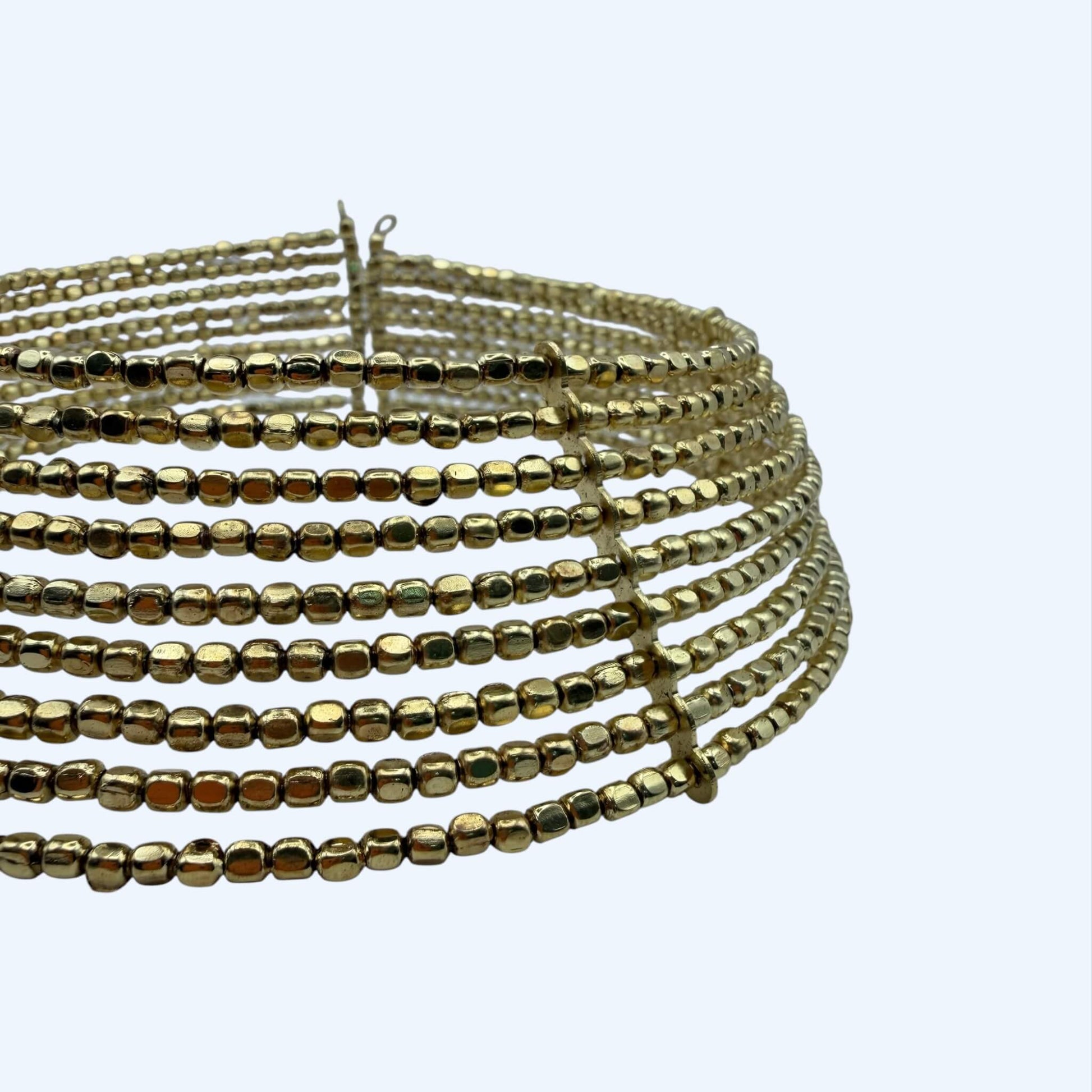 Vista do detalhe do Choker grande dourado com peças metálicas feito à mão.
