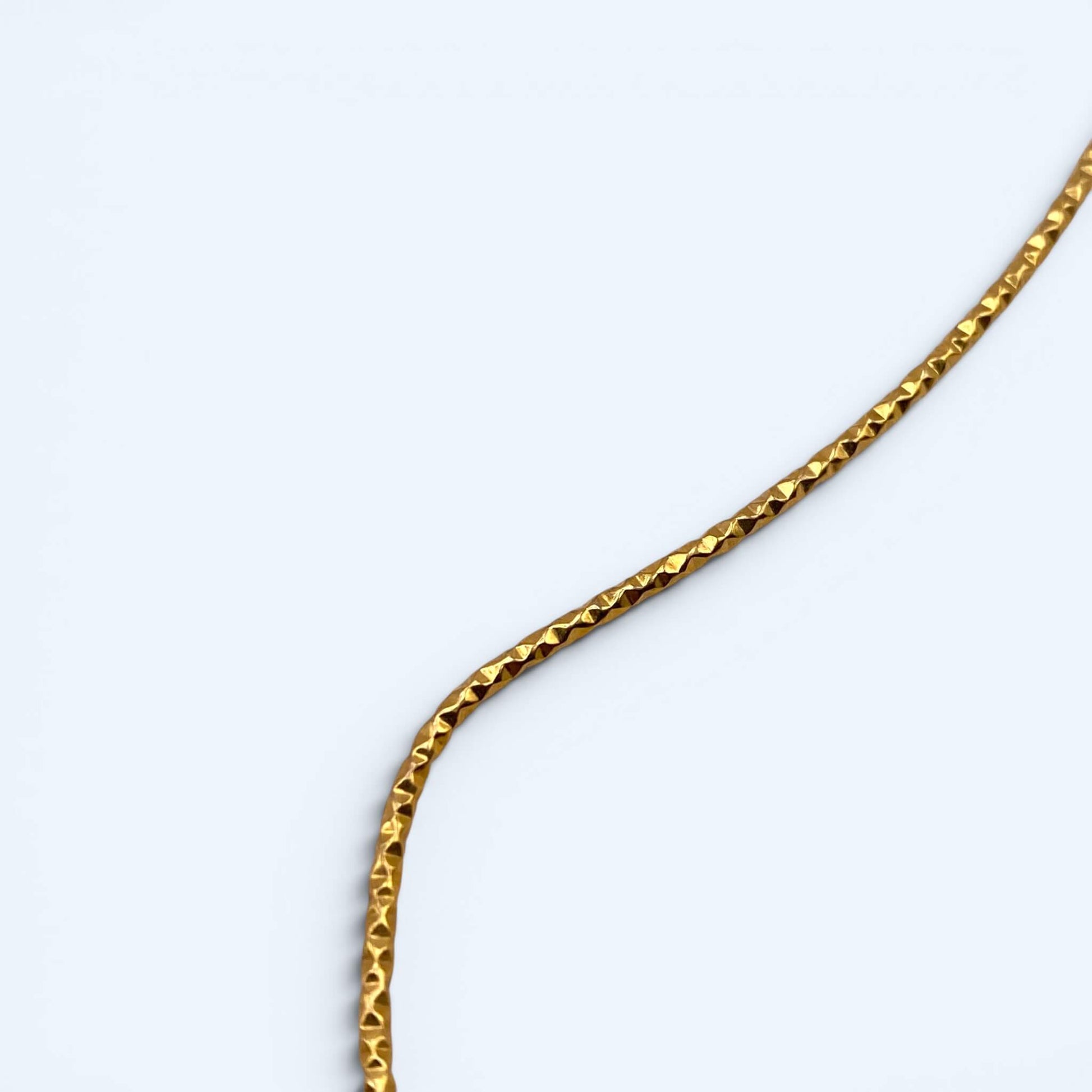 Vista em detalhe do Colar dourado aberto com amonites. De inspiração orgânica com fósseis e acabamento texturizado, é a gargantilha perfeita para cerimónias, festivais, festas de verão e looks mais glamorosos.