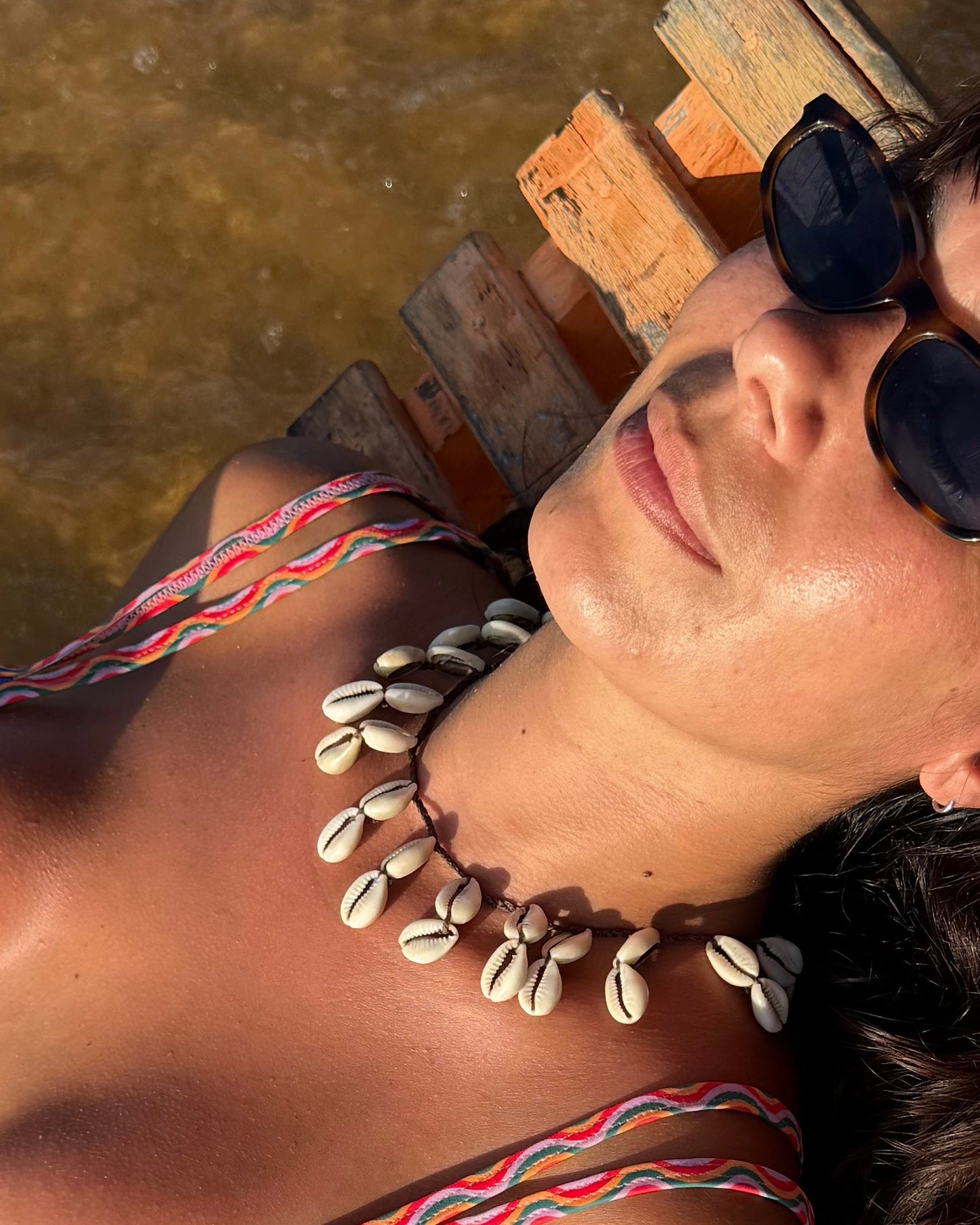 Colar com búzios cauri naturais em cordão entrançado castanho ajustável. Este colar surfer é um colar de búzios para usar em festas, festivais e dias de verão. Colar boho casual que ajusta como gargantilha de búzios ou colar comprido de búzios. A ser usado como gargantilha de búzios.