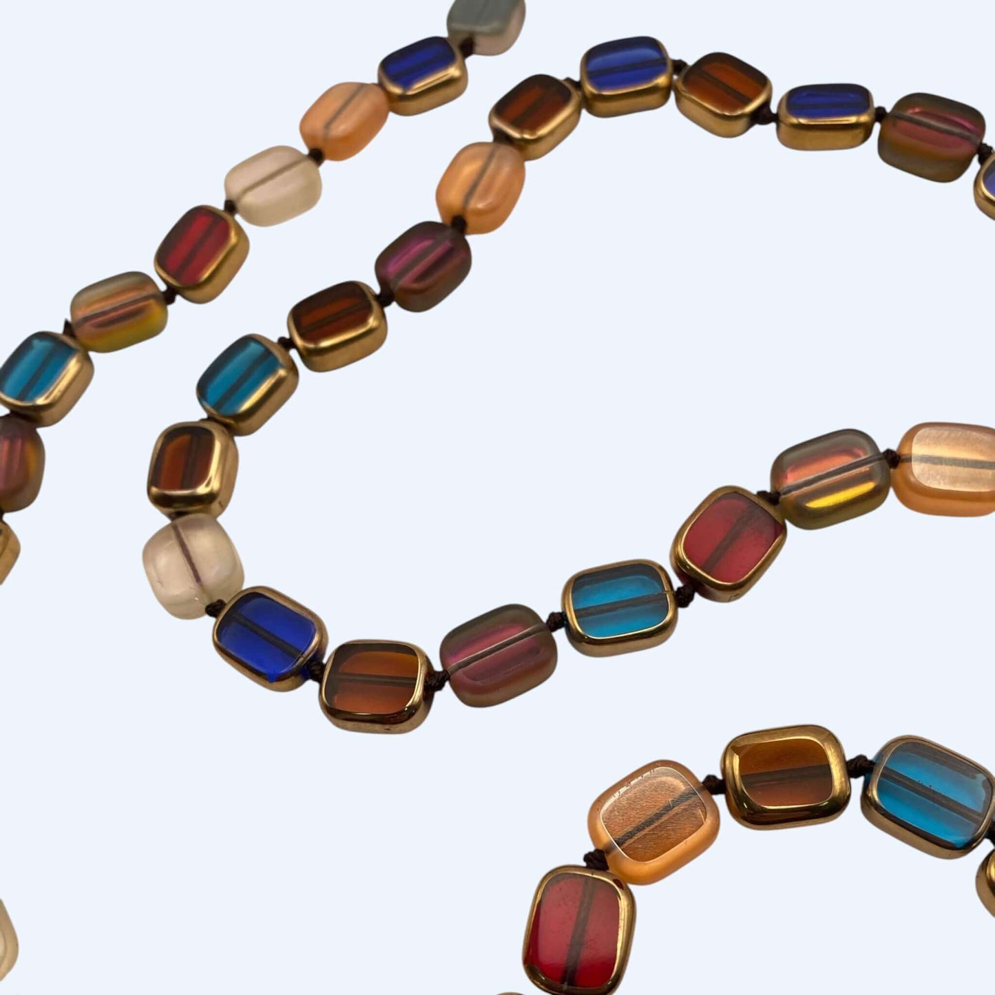 Vista em detalhe do Colar longo colorido com peças retangulares translúcidas e vibe boho. Um colar cool, para usar com  várias voltas, como pulseira ou cinto. Este colar é um clássico chic.
