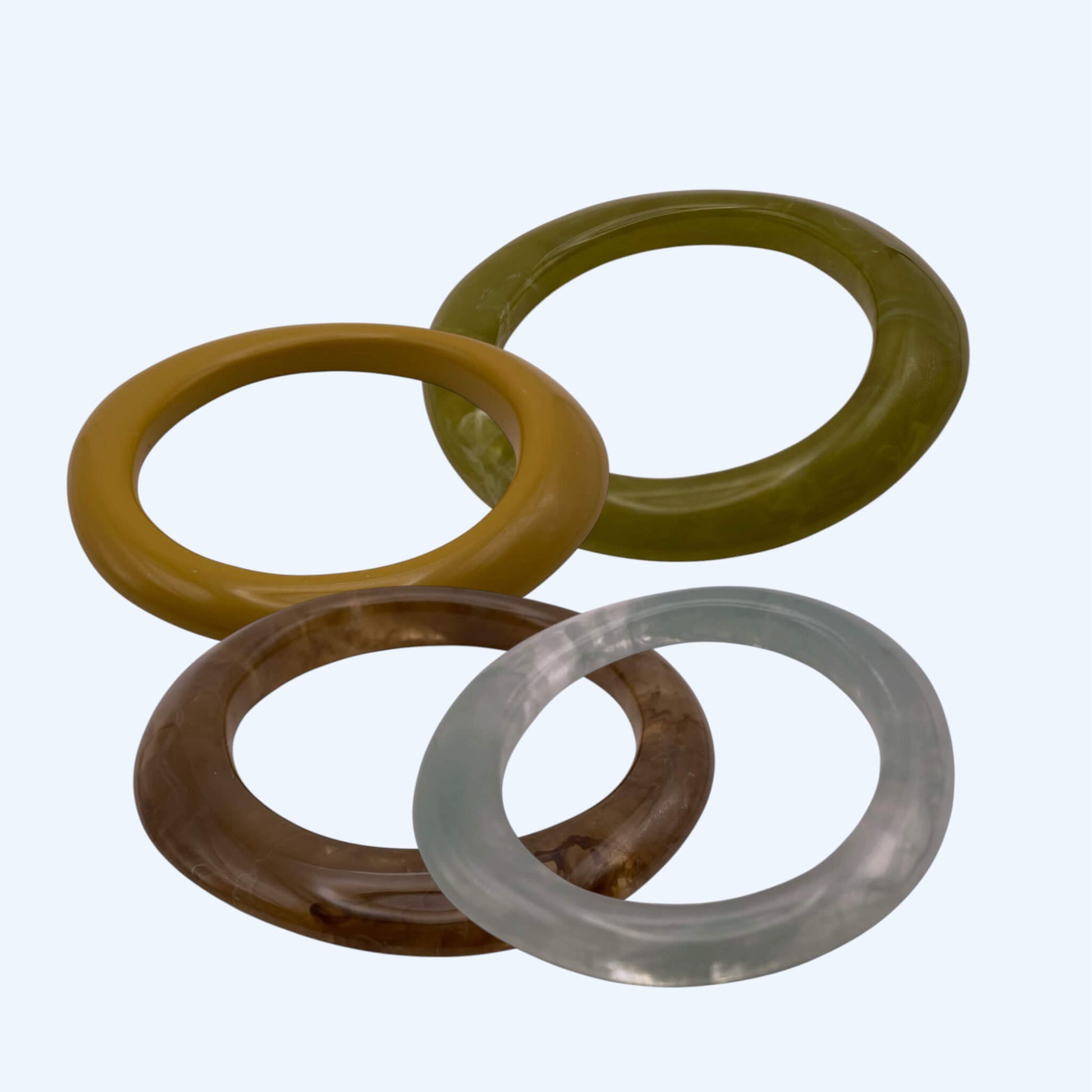 Vista lateral de conjunto de várías Pulseiras bangle em resina, com acabamento glossy. Pulseiras para serem usadas sozinhas ou em conjunto com outras pulseiras. Pulseira ideal para estilo boho, para estética de verão e da cidade.