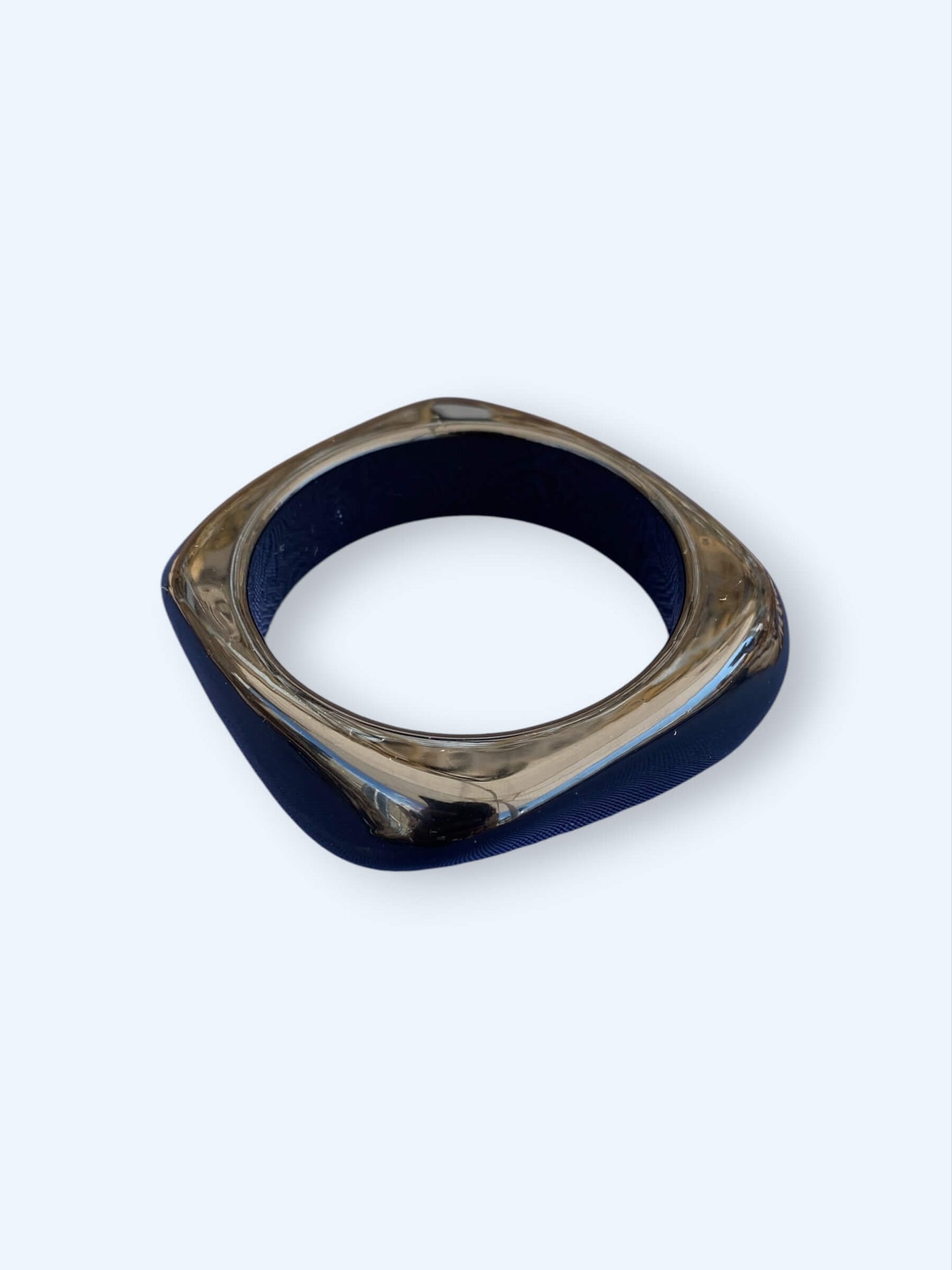 Vista da pulseira preta que pertence ao Conjunto de três pulseiras em resina. Estas pulseiras tem acabamento glossy e são dos tons pretos e castanho, são perfeitas para combinar com tudo ou para usar sem nada. São o acessório perfeito para o verão.