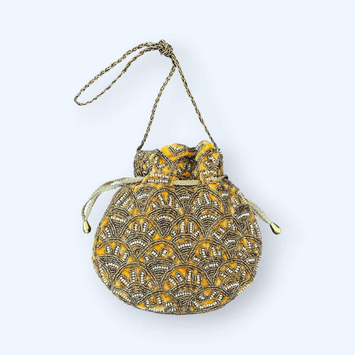 Vista frontal da Mala bucket dourada bordada com missangas que combina textura, brilho e um mood boho. O padrão artesanal e o tom dourado são perfeitos para looks de festa e looks de verão. é uma mala boho.