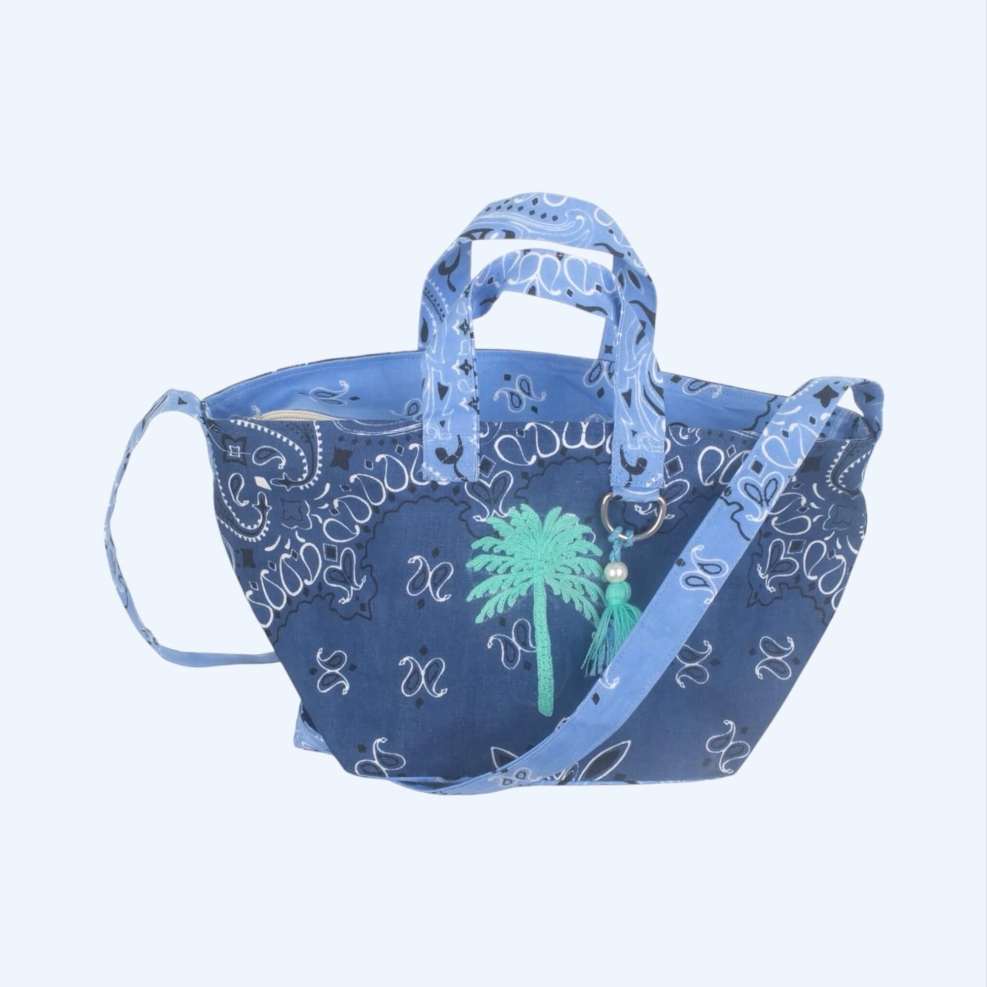Mala de verão tiracolo e de mão com padrão bandana azul e estampagem tropical com palmeira.
