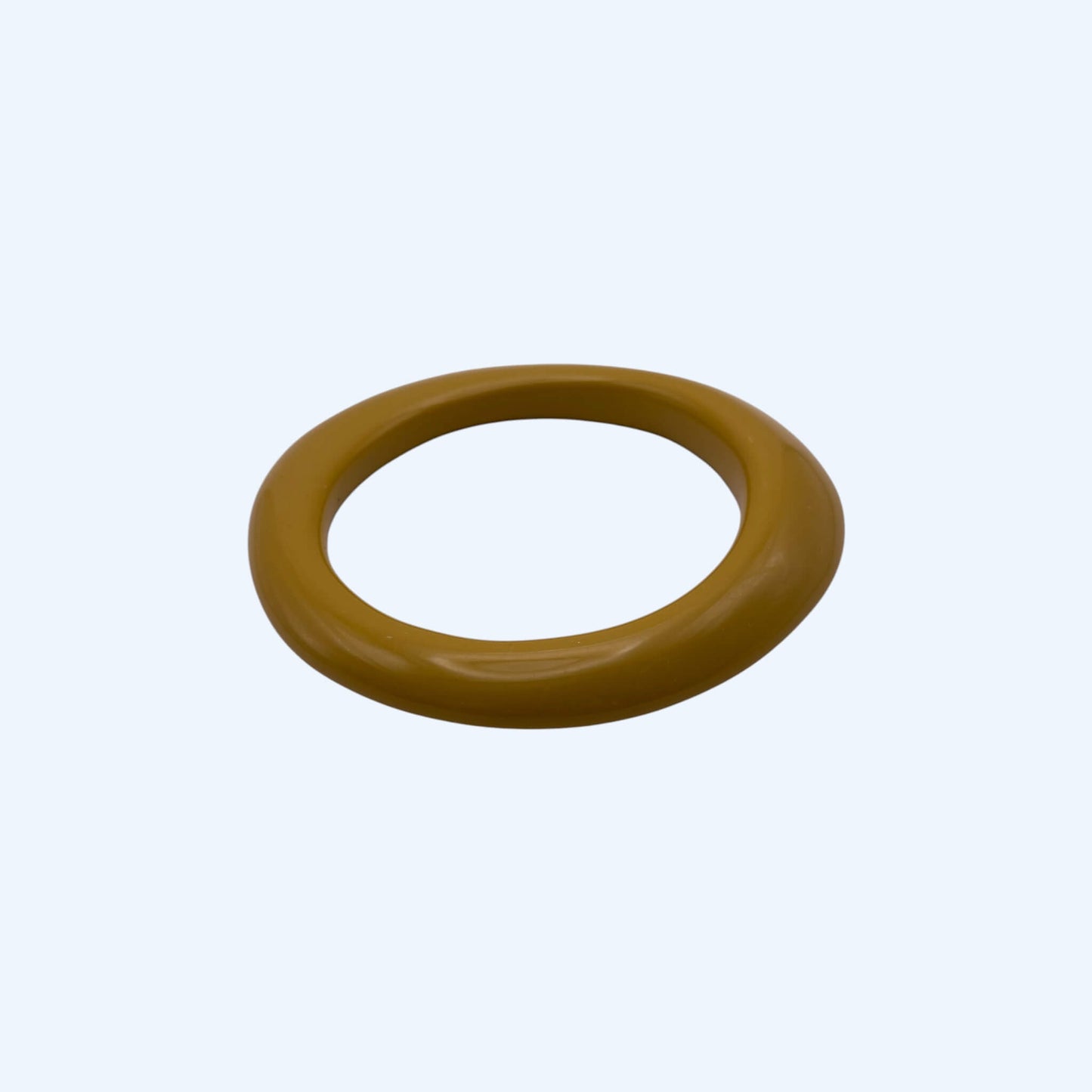 Vista lateral da Pulseira bangle amarela mostarda em resina, com acabamento glossy. Pulseira para ser usada sozinha ou em conjunto com outras pulseiras. Pulseira ideal para estilo boho, para estética de verão e da cidade.