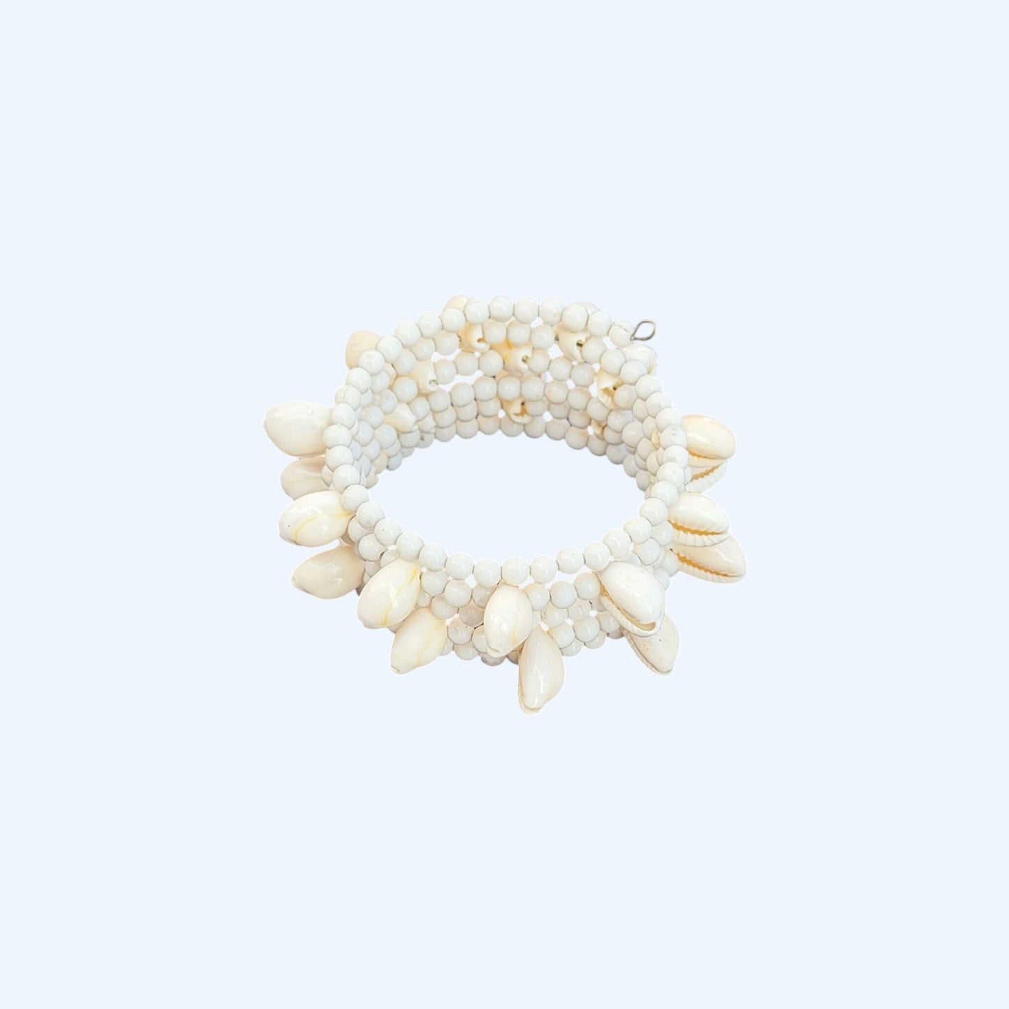 Vista lateral da Pulseira ajustável com missangas brancas grandes e búzios. Pulseira leve e descontraída perfeita para looks de verão, na praia e na cidade. Pulseira ideal para festivais e festas.