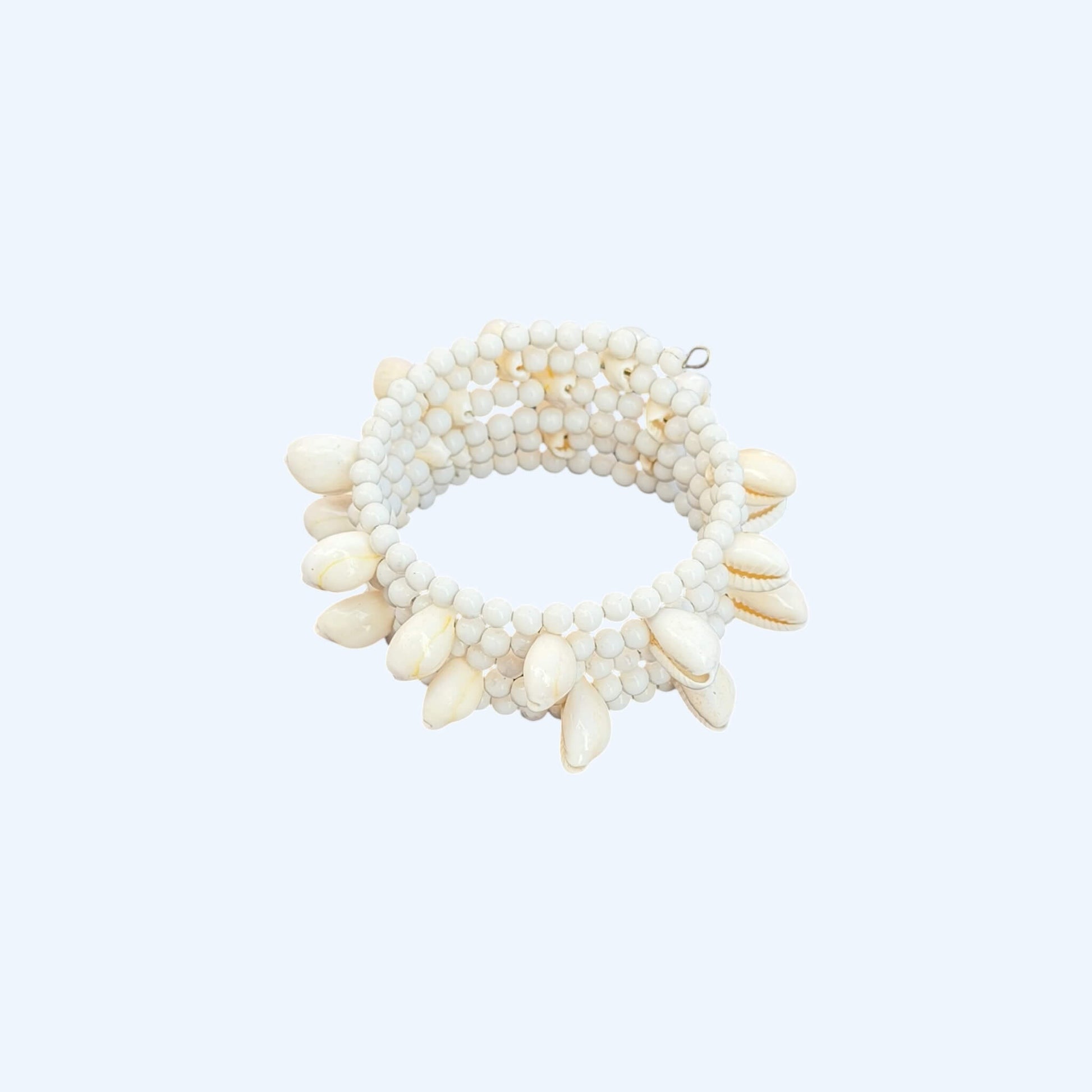 Vista lateral da Pulseira ajustável com missangas brancas grandes e búzios. Pulseira leve e descontraída perfeita para looks de verão, na praia e na cidade. Pulseira ideal para festivais e festas.