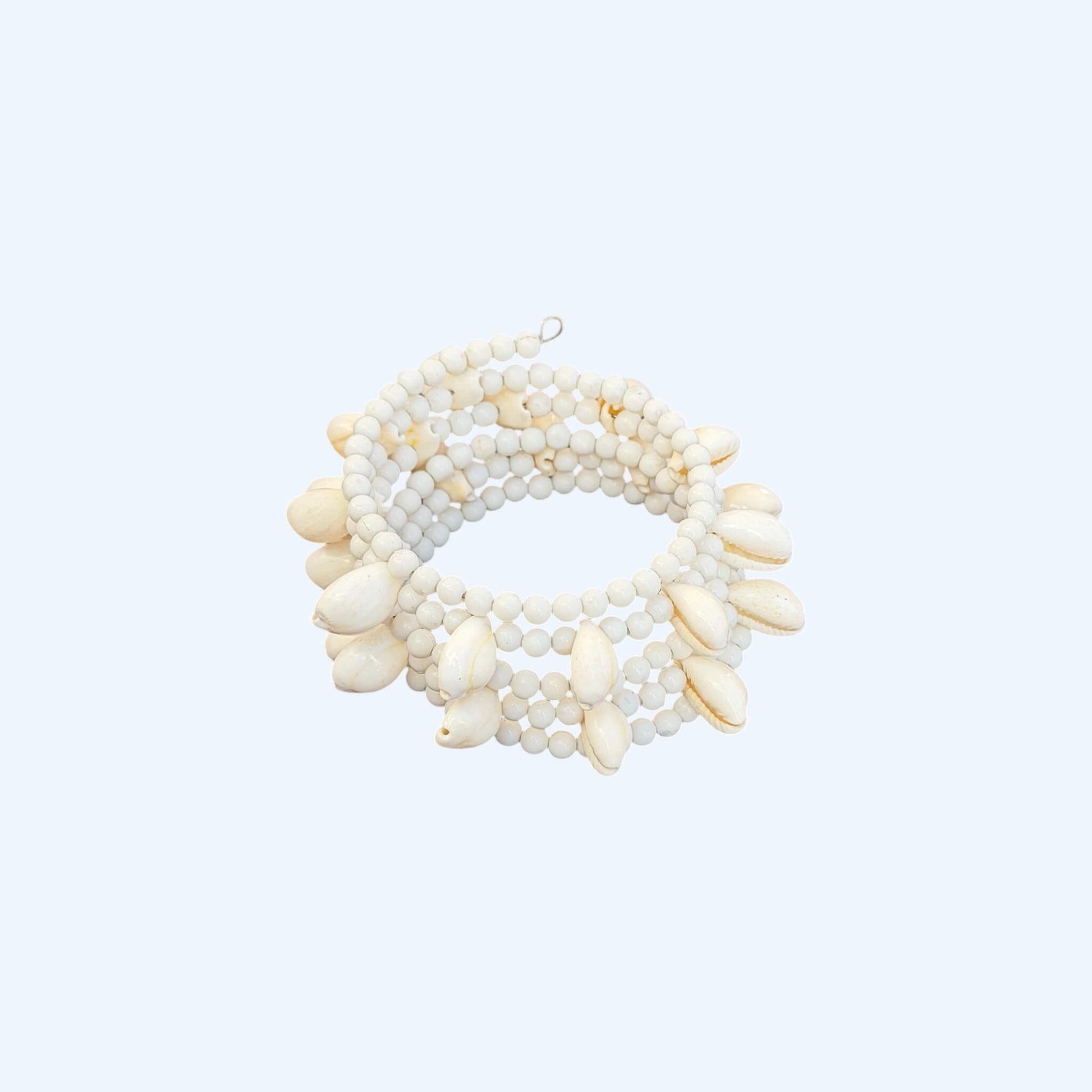 Vista frontal da Pulseira ajustável com missangas brancas grandes e búzios. Pulseira leve e descontraída perfeita para looks de verão, na praia e na cidade. Pulseira ideal para festivais e festas.
