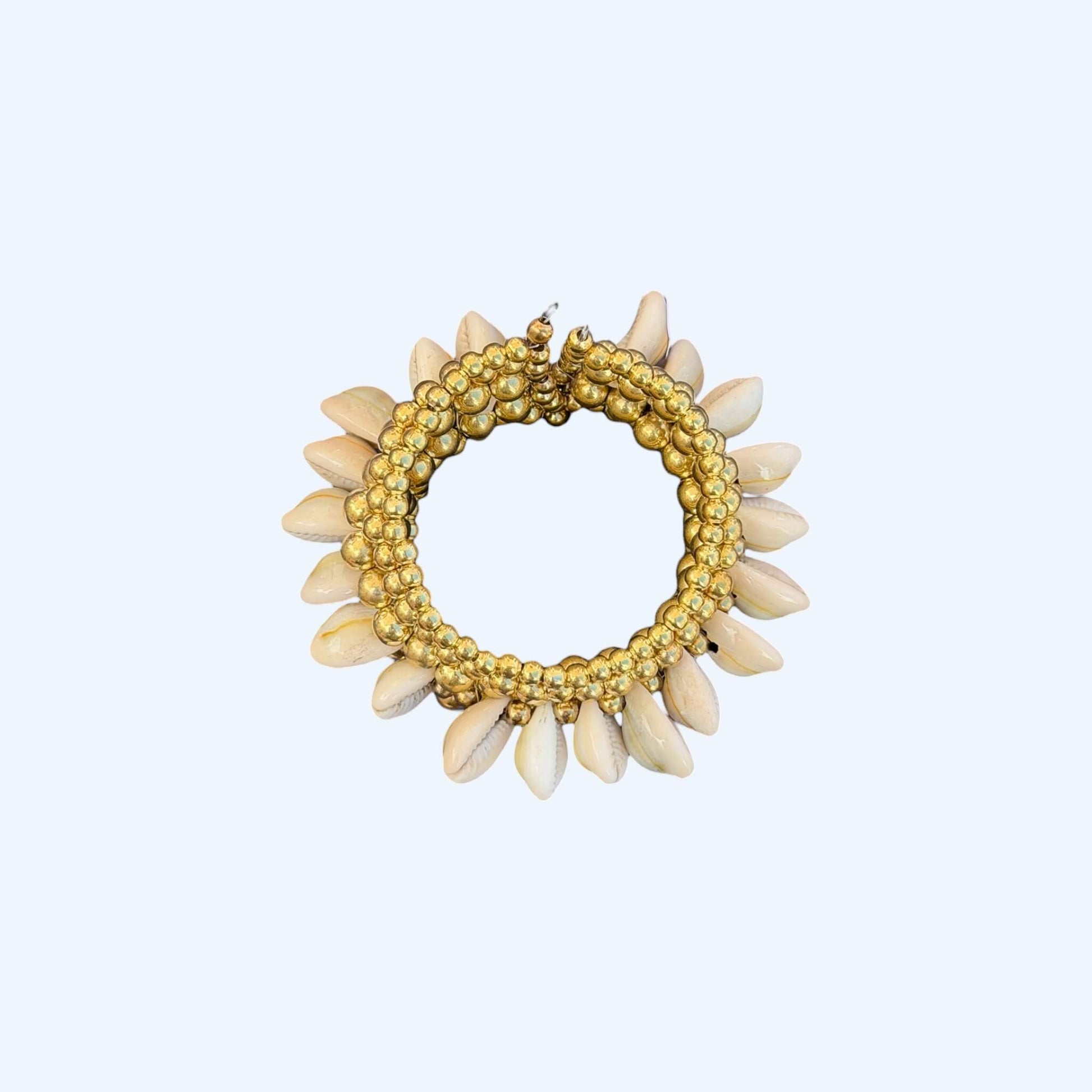 Vista superior da Pulseira com búzios naturais e esferas douradas metálicas. Esta pulseira tem uma estética mix cool entre um tribal e boho beachy. É uma pulseira com búzios serve aos looks mais basic aos mais irreverentes.