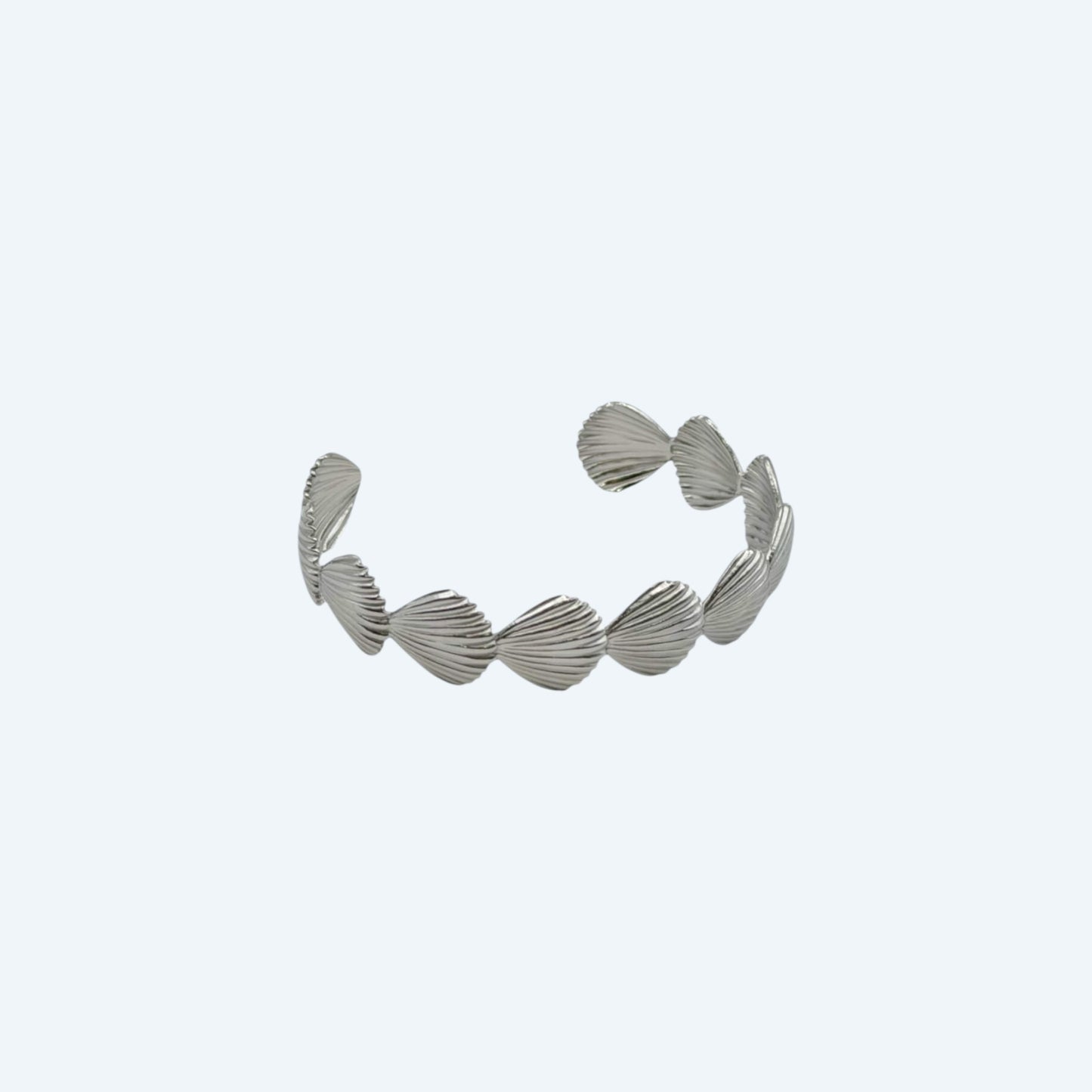 Vista lateral da Pulseira prateada com conchas em aço inoxidável de bracelete ajustável. Com vibe beach girl, esta pulseira é um detalhe do oceano para ser usado todos os dias ou em festas e festivais.