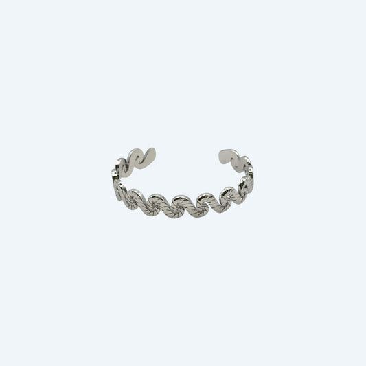 Vista frontal da Pulseira prateada com com ondas de bracelete ajustável em aço inoxidável. É uma Pulseira com curvas que formam ondas. É uma pulseira de estética bold mas fácil de usar em qualquer look.