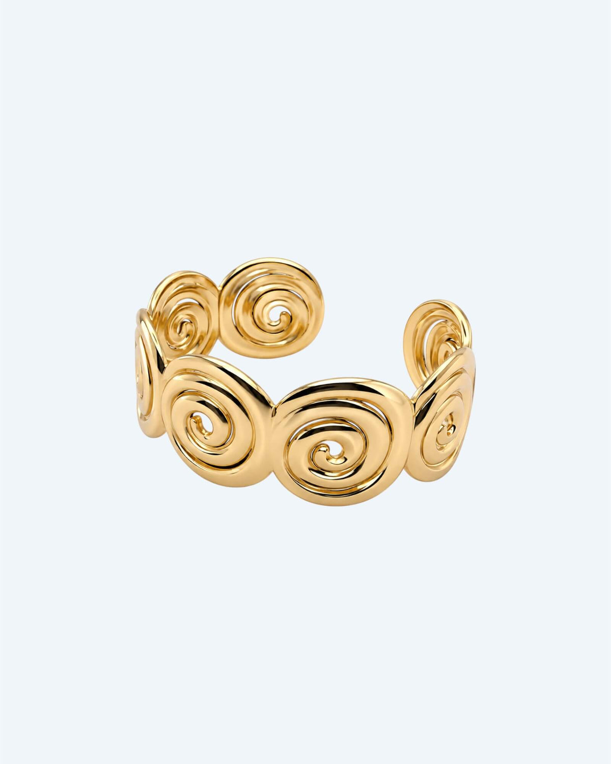 Vista de frente com inclinação da Pulseira dourada rígida mas ajustável em aço inoxidável, composta por espirais recortadas e acabamento polido. Esta pulseira é ideal para looks boho ou urbanos, também para mais artisticos e de quem pretende ser simples com um detalhe ou para quem pretende juntar a um estilo bold. 