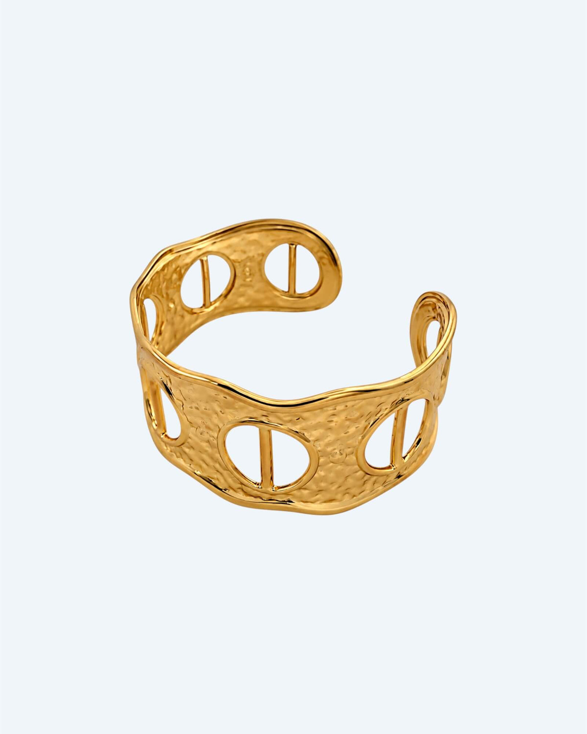 Vista de frente da Pulseira dourada rígida, ajustável, em aço inoxidável, martelada com aberturas. Esta pulseira é uma versão contemporânea de boho vintage. É para quem gosta de looks marcantes ou para quem procura uma pulseira para usar numa ocasião especial ou cerimónia.