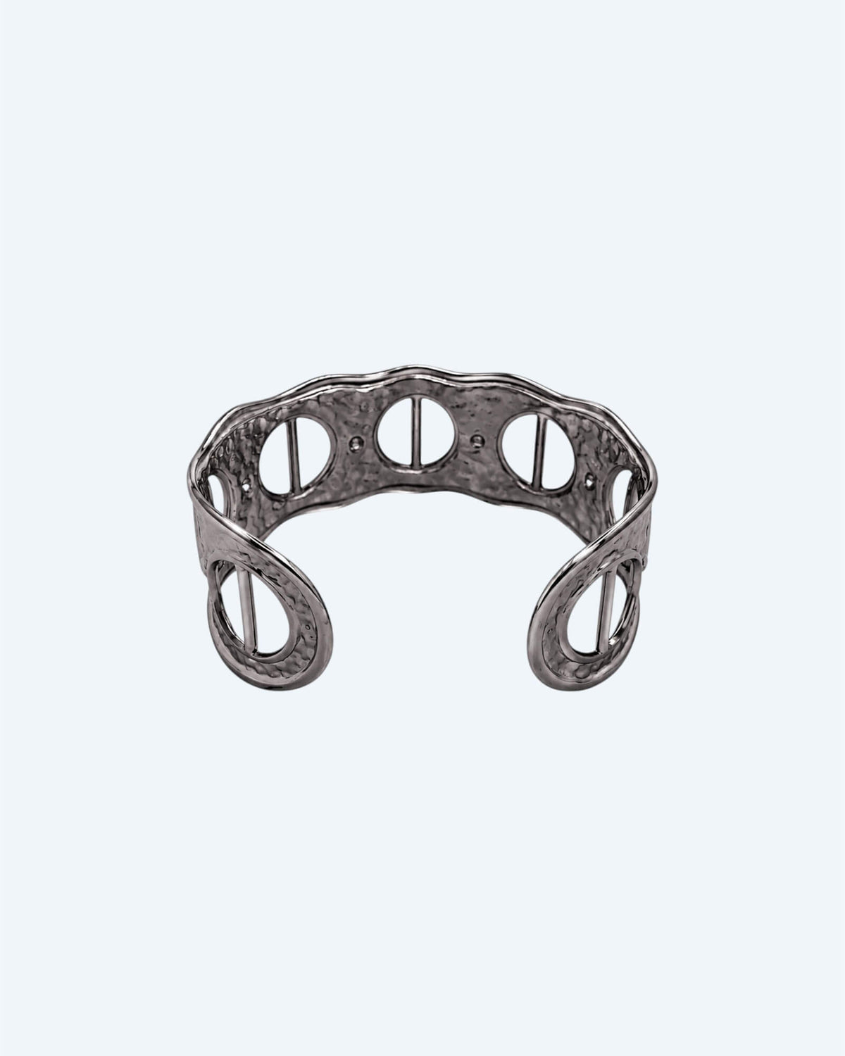 Vista de trás da Pulseira prateada rígida, ajustável, em aço inoxidável, martelada com aberturas. Esta pulseira é uma versão contemporânea de boho vintage. É para quem gosta de looks marcantes ou para quem procura uma pulseira para usar numa ocasião especial ou cerimónia.