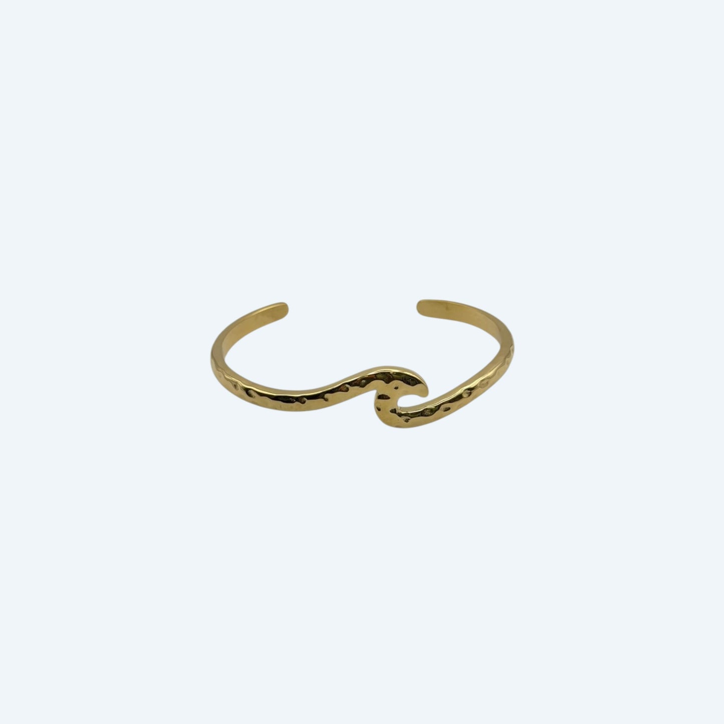 Pulseira dourada com formato de onda, de bracelete ajustável em aço inoxidável. É uma pulseira clean e minimal para quem ama o mar. Fácil de usar em qualquer look.