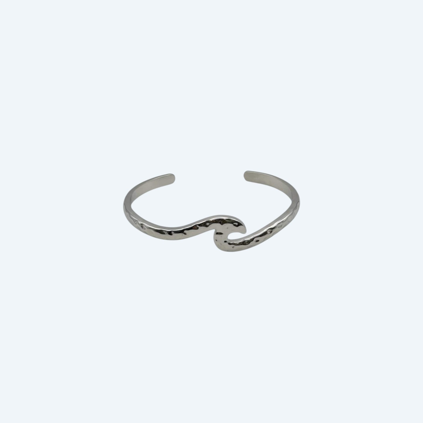 Pulseira prateada com formato de onda, de bracelete ajustável em aço inoxidável. É uma pulseira clean e minimal para quem ama o mar. Fácil de usar em qualquer look.
